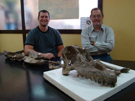Matt and paleontologist with sarmientosaurus skull