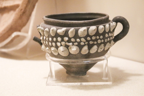 Brown clay Egyptian pot with one complete handle and one broken handle embellished with white dot decorations