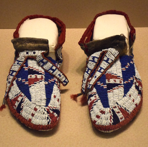 white, blue, red, and brown beaded moccasin shoes 