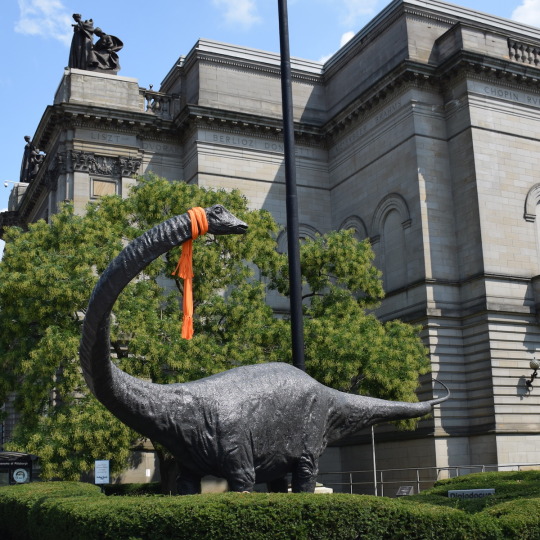 Dippy dinosaur statue with orange scarf 