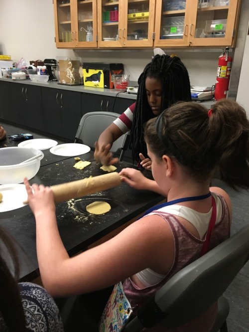 campers rolling out dough with rolling pins