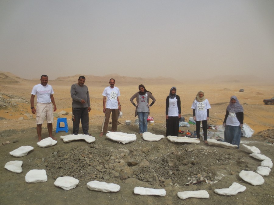 group of scientists standing around an excavation site