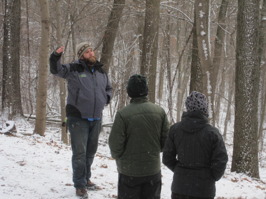a guide giving a tour in the woods in thesnow