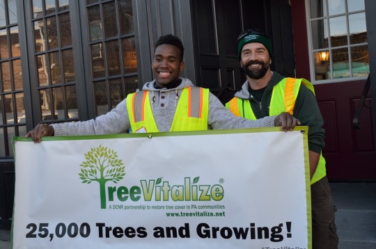 two men holding a sign for Tree Vitalize
