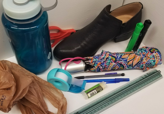 Items made with plastic: water bottle, shoe, scissors, umbrella, pens, chapstick, grocery bag, tape dispenser. 