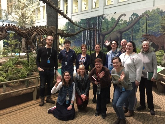 group of interpreters in from of dinosaur display