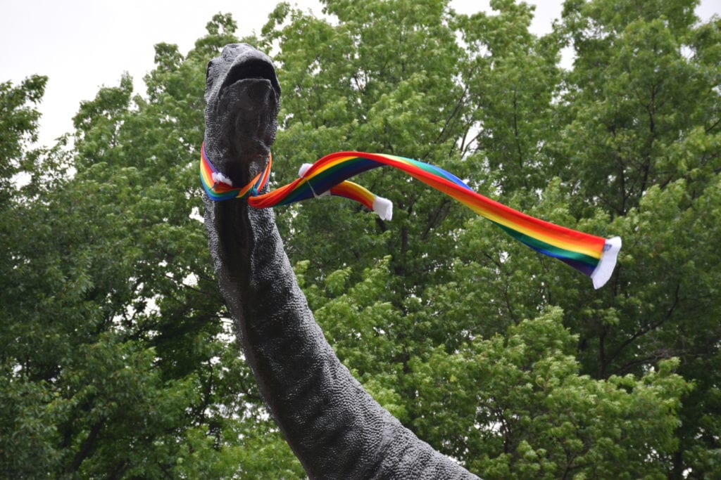 sauropod statue with rainbow scarf