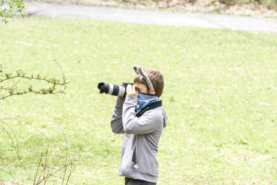 photograph of a boy with a camera in a field