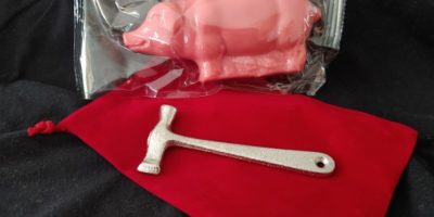 pink peppermint pig with red bag and small silver hammer