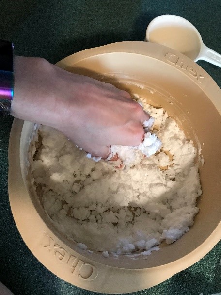 Hand mixing the wet and dry ingredients of the DIY snow