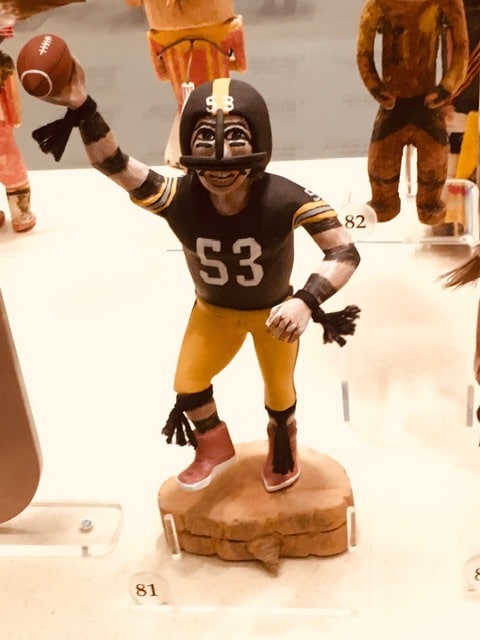 carved figure of a Pittsburgh Steelers football player holding a football