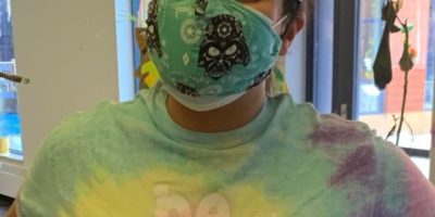 woman wearing a mask and tie-dye t-shirt