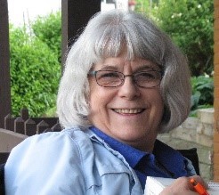 woman with glasses and gray hair sitting outside
