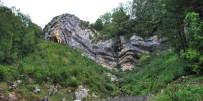 car parked in front of a rock formation that looks like it was folded