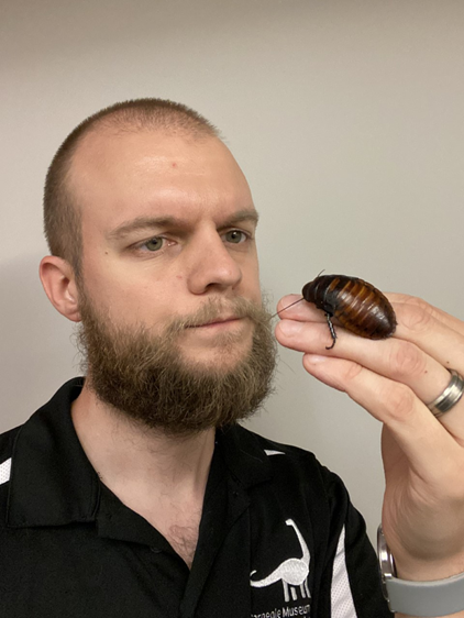Man holding a cockroach. 