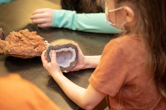 kid looking at a mineral