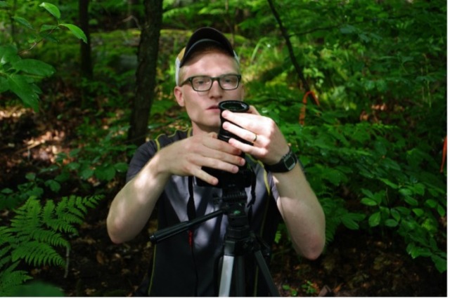 Man setting up equipment in a forested area