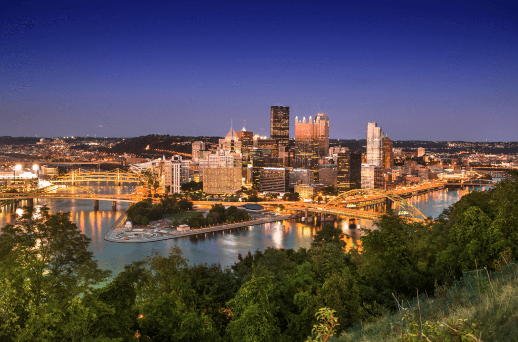 Pittsburgh skyline at night with lights on. 