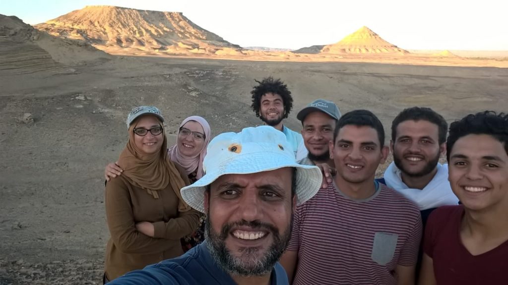 A group of people posing for a selfie in the desert