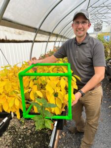 Joe Stavish with a biocube in a greenhouse