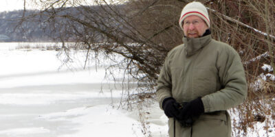 Pat McShea standing next to an icy river