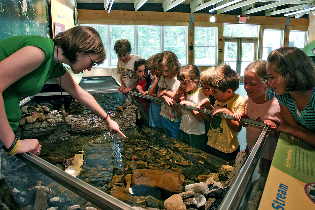 An educator shows children a pond exhibit at PNR