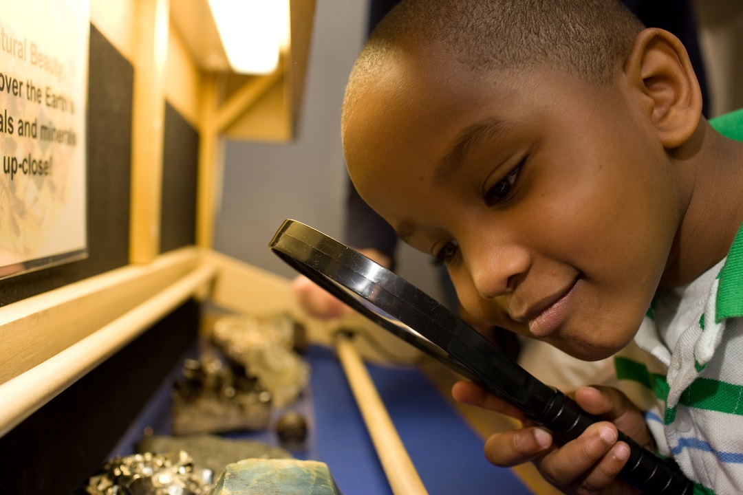 child looking through a magnifying glass